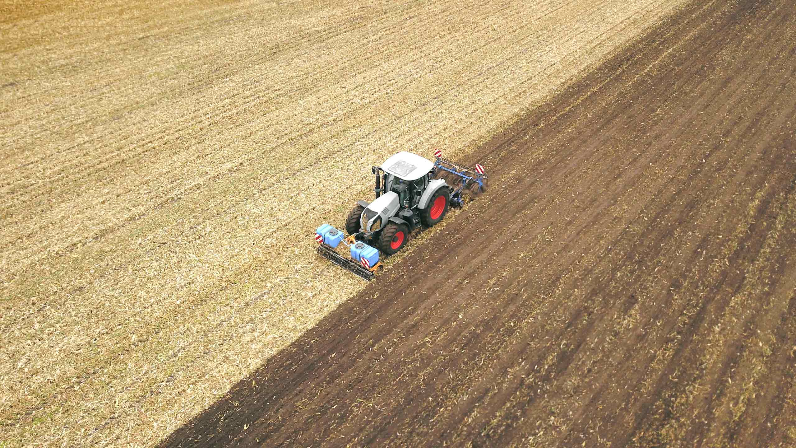 Ein Traktor pflügt ein Feld, um den Boden für die Aussaat vorzubereiten.